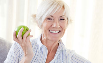 Woman with dental implants can eat an apple